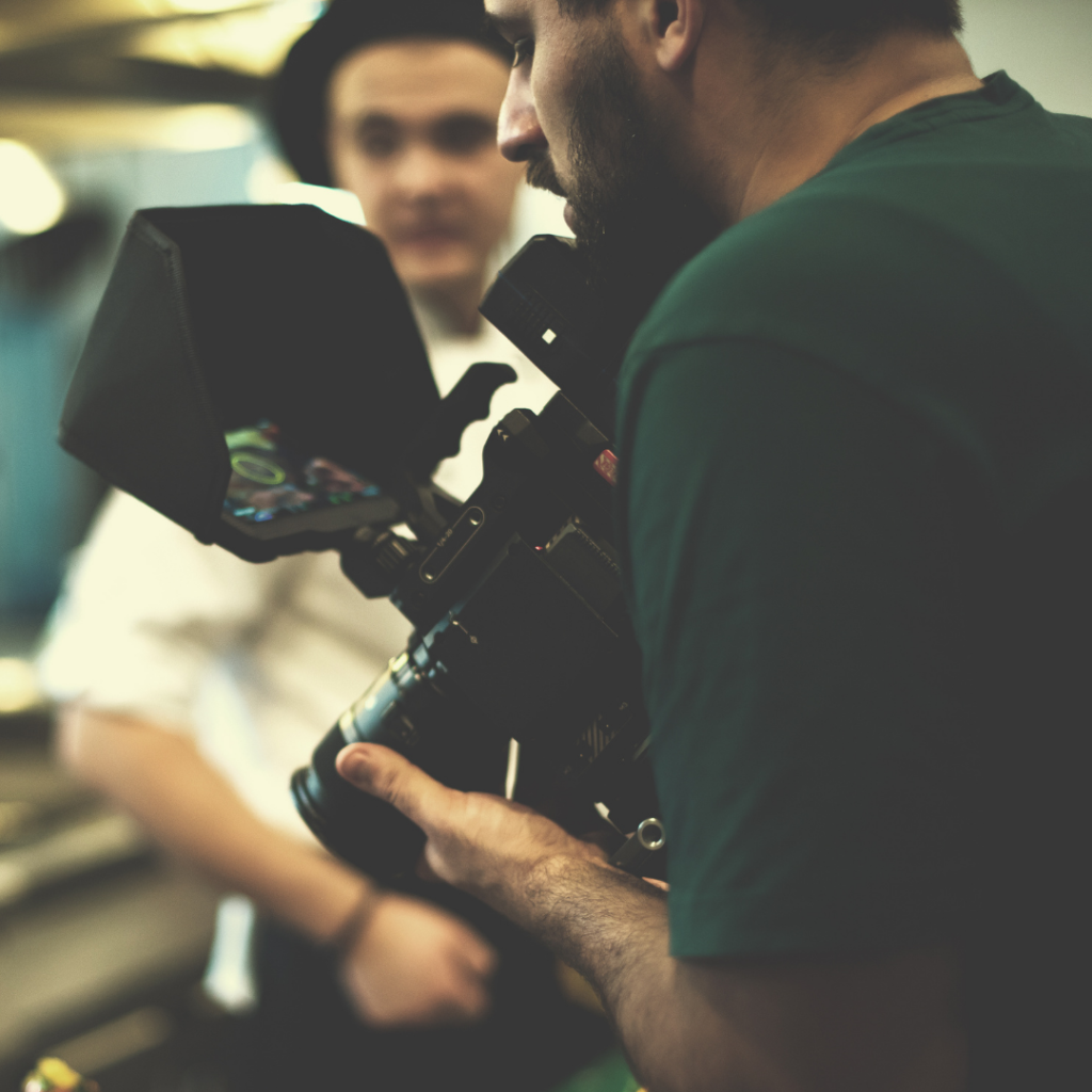 Bearded man holding video camera