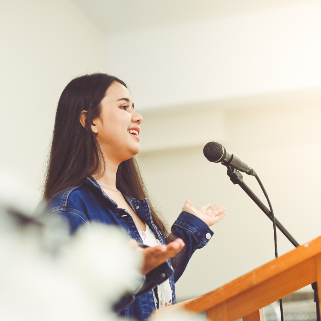 Woman standing at microphone on podium